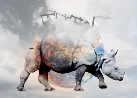Double exposure of rhinoceros and conceptual image depicting Earth destroying by global warming and industrial pollutionの写真素材