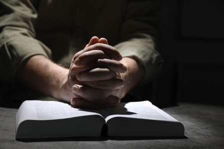 Religion. Christian man praying over Bible at table, closeupの写真素材