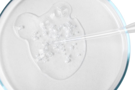 Glass pipette and petri dish with liquid on white background, top viewの写真素材