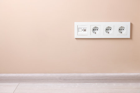 Electric power sockets on beige wall, space for textの写真素材