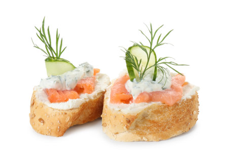 Tasty canapes with salmon, cucumber, cream cheese and dill isolated on whiteの写真素材