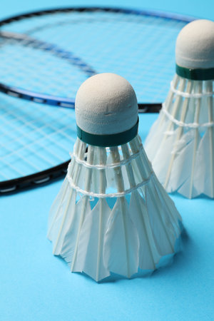Feather badminton shuttlecocks and rackets on light blue background, closeupの写真素材