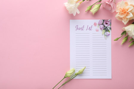 Guest list and beautiful flowers on pink background, flat lay. Space for textの写真素材