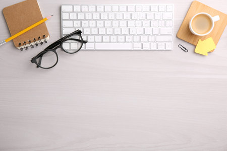 Flat lay composition with different office stationery on white wooden table, space for textの写真素材