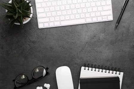 Flat lay composition with different office stationery on dark gray table, space for text