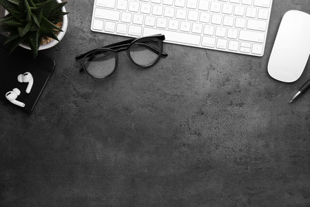 Flat lay composition with different office stationery on dark gray table, space for textの写真素材