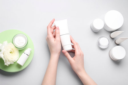 Woman holding tube of cream on light background, top viewの写真素材