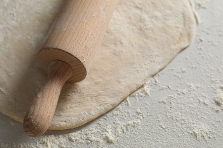 Raw dough and rolling pin on table, closeupの写真素材