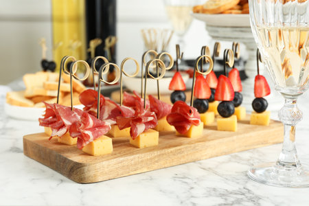 Different tasty canapes on white marble table, closeupの写真素材