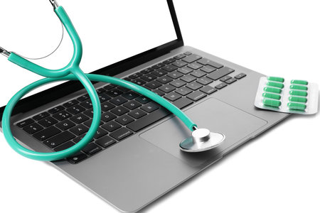 Laptop, stethoscope and pills on white backgroundの写真素材