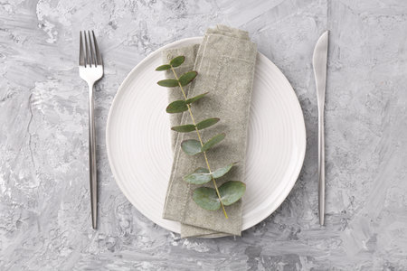 Elegant setting with silver cutlery on gray textured table, flat lay