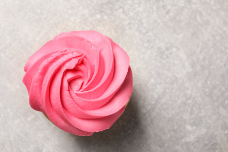 Delicious cupcake with bright cream on gray table, top view. Space for textの写真素材