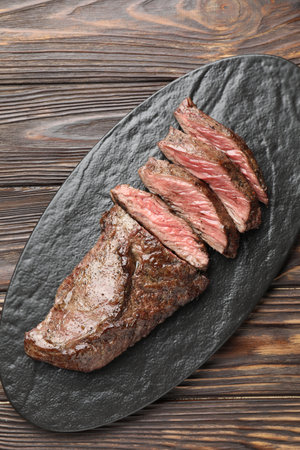 Pieces of delicious grilled beef meat on wooden table, top viewの写真素材