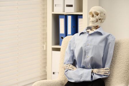 Waiting concept. Human skeleton sitting in armchair at office, space for textの写真素材