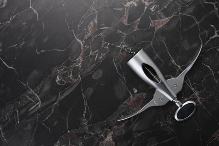 One wing corkscrew on black marble table, top view. Space for textの写真素材
