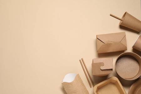 Eco friendly food packaging. Different paper containers on beige background, flat lay. Space for textの写真素材