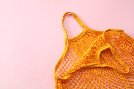 Orange string bag on pink background, top view. Space for textの写真素材