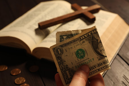 Donate and give concept. Woman holding dollar banknote at table, closeup
