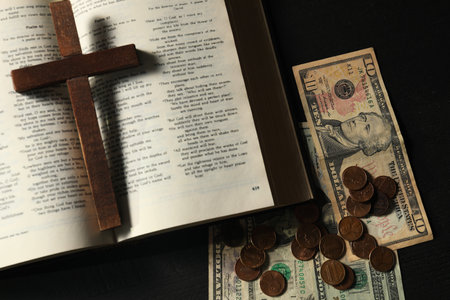 Donate and give concept. Coins, dollar banknotes, cross and Bible on dark table, flat layの写真素材