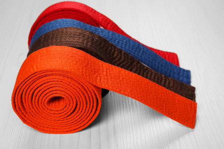 Colorful karate belts on wooden background, closeupの写真素材