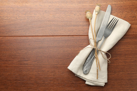 Stylish setting with cutlery and napkin on wooden table, top view. Space for textの写真素材