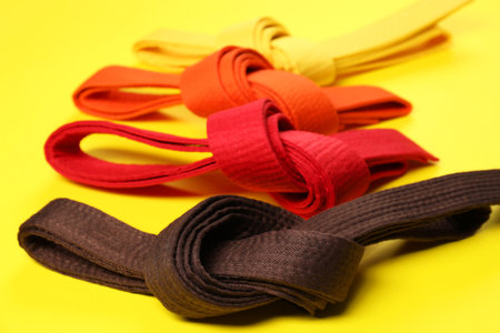 Colorful karate belts on yellow background, closeupの写真素材