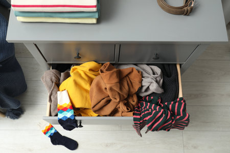 Cluttered chest of drawers indoors, above view. Clothes in messの写真素材