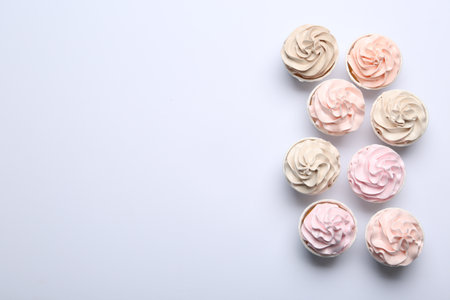 Many tasty cupcakes on white background, flat lay. Space for textの写真素材