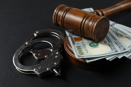 Judge's gavel, money and handcuffs on black background, closeupの写真素材