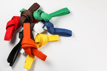 Colorful karate belts on white background, flat lay. Space for textの写真素材