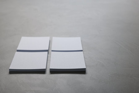 Blank paper sheets on gray textured table, closeup. Mockup for designの写真素材