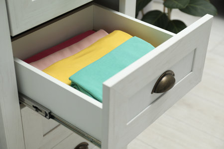 Chest of drawers with different folded clothes indoorsの写真素材