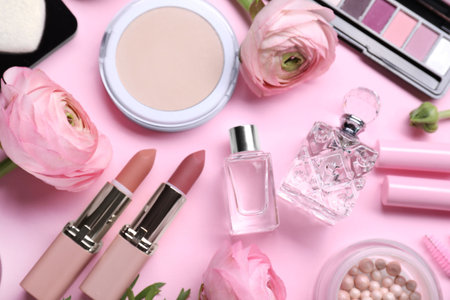 Flat lay composition with different makeup products and beautiful spring flowers on pink backgroundの写真素材