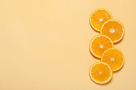 Slices of juicy orange and water on beige background, flat lay. Space for text