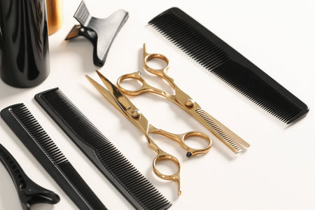 Hairdresser tools. Different scissors and combs on white table, closeupの写真素材