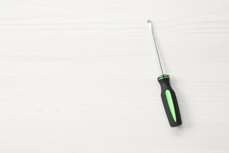 Screwdriver with black handle on white wooden table, top view. Space for textの写真素材
