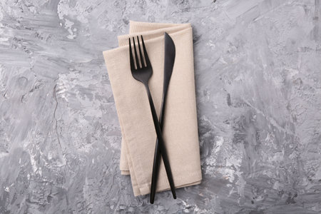 Elegant cutlery and kitchen towel on gray textured table, top viewの写真素材