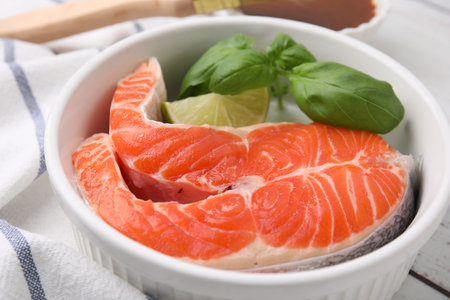 Fresh marinated fish and lime on white wooden table, closeupの写真素材