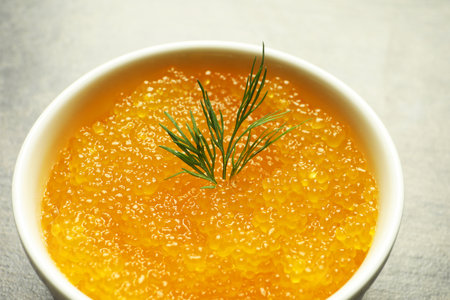 Fresh pike caviar and dill in bowl on gray table, closeupの写真素材