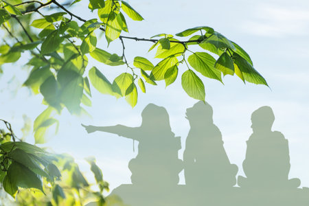 Silhouettes of children and trees outdoors, double exposureの写真素材