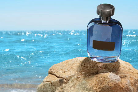 Bottle of aquatic perfume on rocks near ocean. Fresh sea breeze scentの写真素材