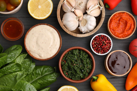 Different fresh marinades in bowls and ingredients on gray wooden table, flat layの写真素材