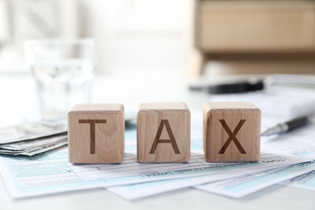 Wooden cubes with word Tax and documents on light table, closeupの写真素材