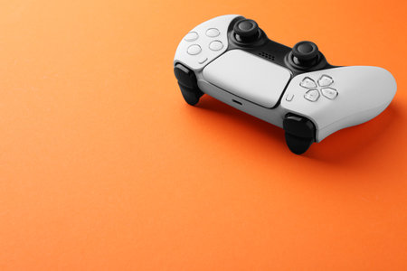 One wireless game controller on orange background. Space for textの写真素材