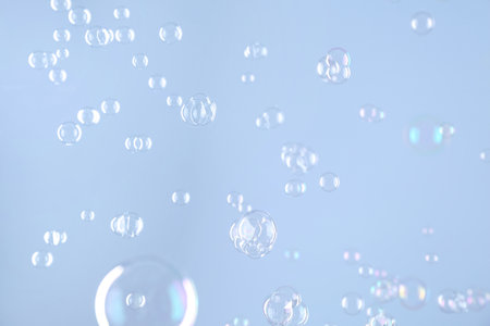 Beautiful transparent soap bubbles on light gray background