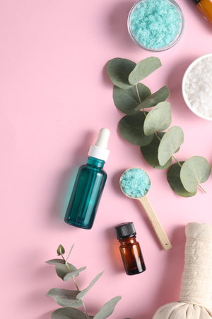 Different aromatherapy products and eucalyptus branches on pink background, flat layの写真素材