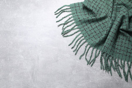 Soft green scarf on light gray background, top view. Space for text