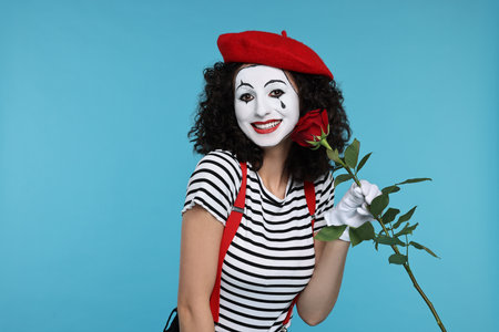 Funny mine with red rose posing on light blue backgroundの写真素材