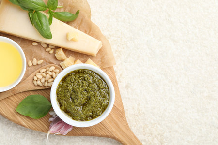 Tasty pesto sauce, basil, pine nuts, garlic, oil and cheese on light gray table, top view. Space for textの写真素材