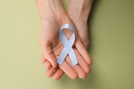International Psoriasis Day. Woman with light blue ribbon as symbol of support on green background, top viewの写真素材